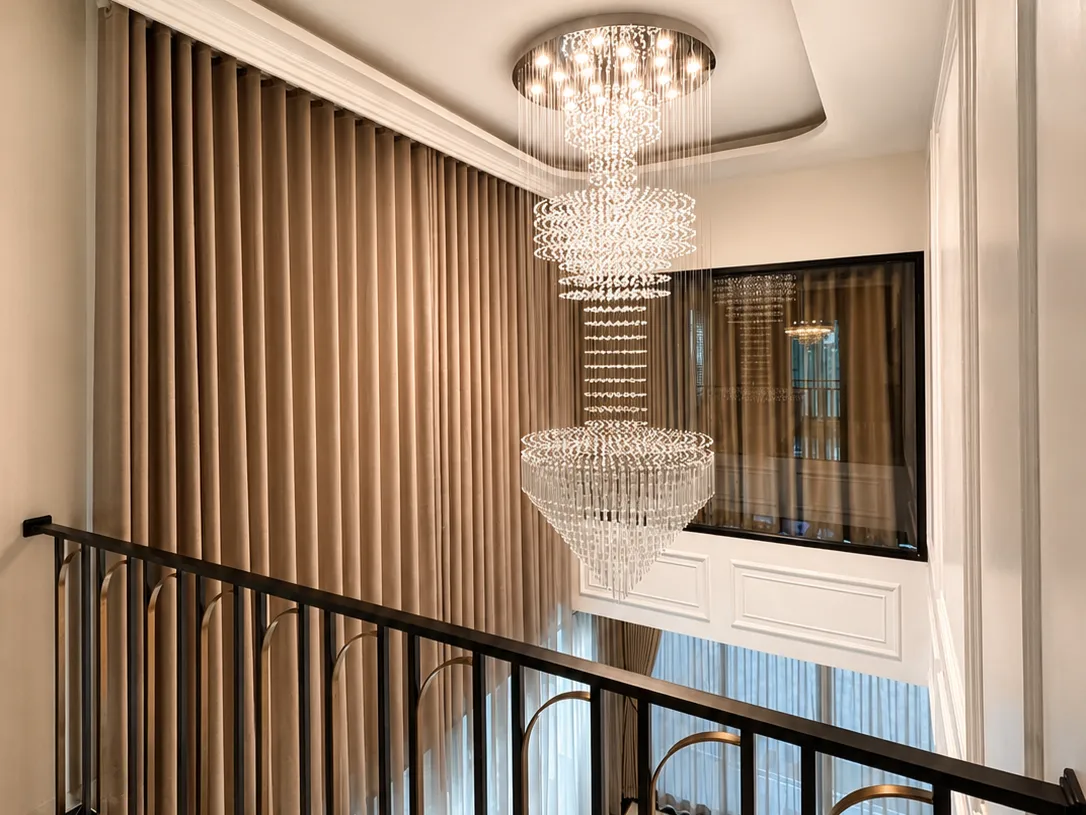 Curtains in a stairwell with a crystal chandelier