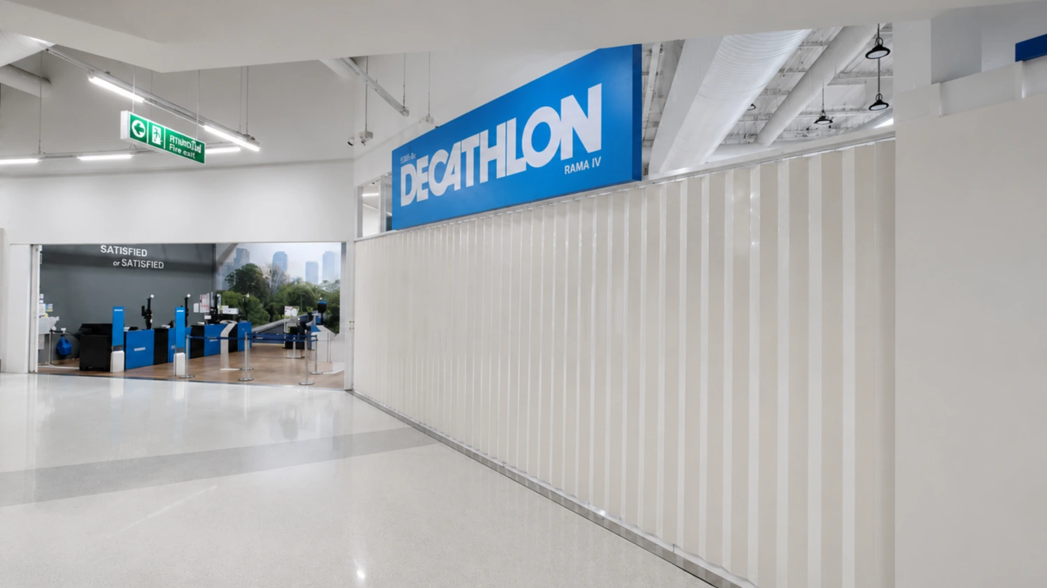 Decathlon Rama IV storefront entrance with a white fluted accordion room divider along the wall