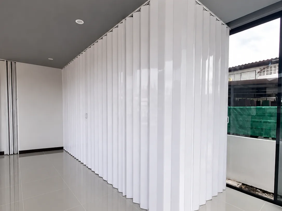White accordion room divider curving along a room's ceiling line