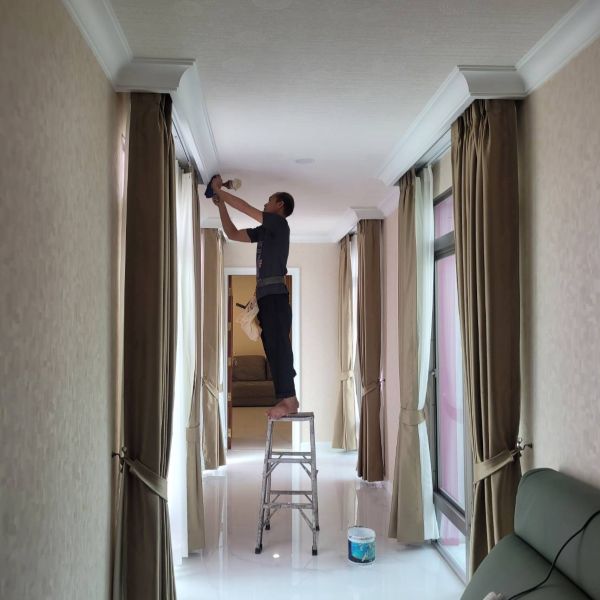 Technician installing curtains on a ladder