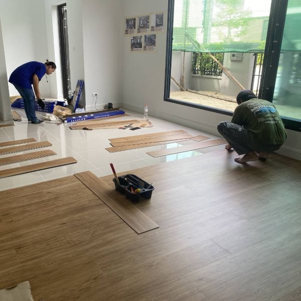 Technicians installing SPC flooring on-site