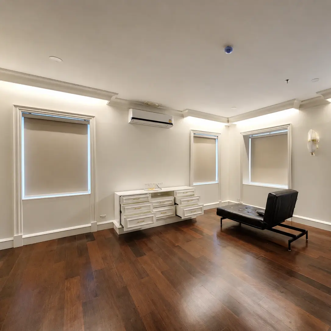 Living room with beige roller blinds on multiple windows and dark wood flooring