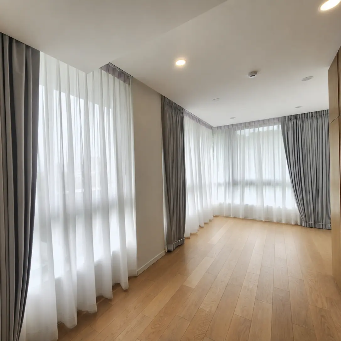 Condo hallway with taupe curtains and sheer under-curtains along floor-to-ceiling windows, wood flooring
