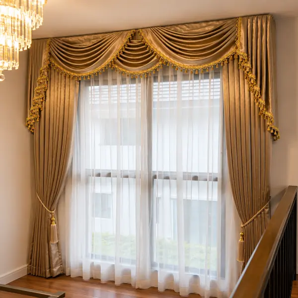 Stairwell landing window with a gold swag-and-tail valance curtain, tassel tiebacks, and a crystal chandelier