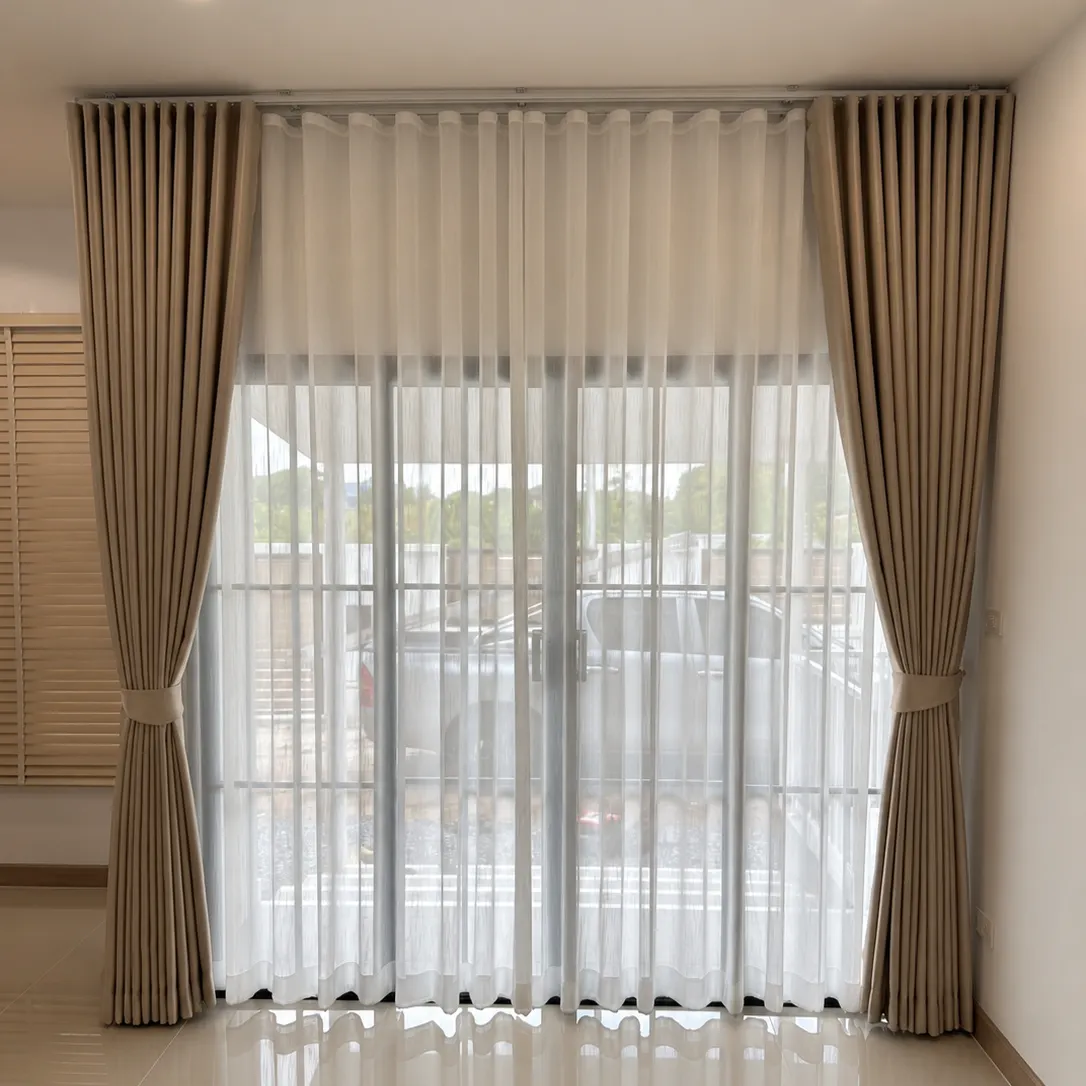 Living room with tan wave-fold curtains and sheer under-curtains tied back over a sliding glass door, wood blinds on the adjacent window