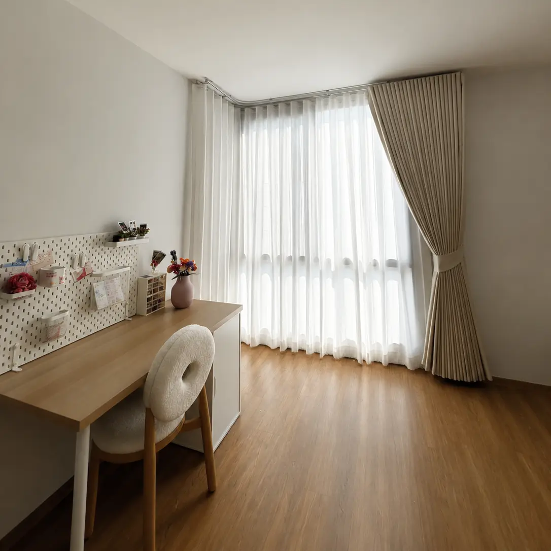 Small bedroom corner with a tan tieback curtain over a corner window beside a desk with a pegboard organizer
