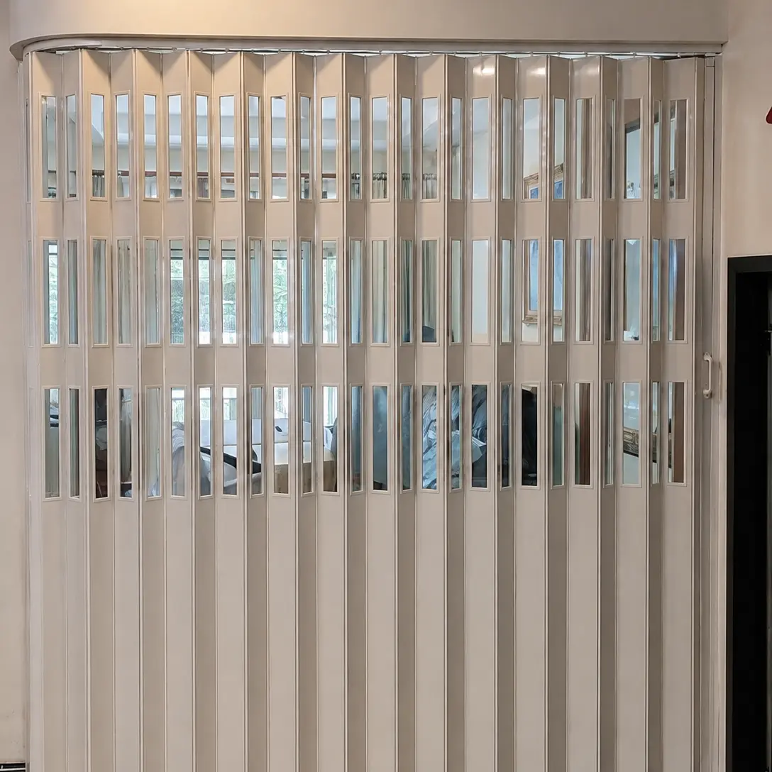 Cream accordion room divider with vertical glass strip windows spanning a wide curved opening, wood flooring
