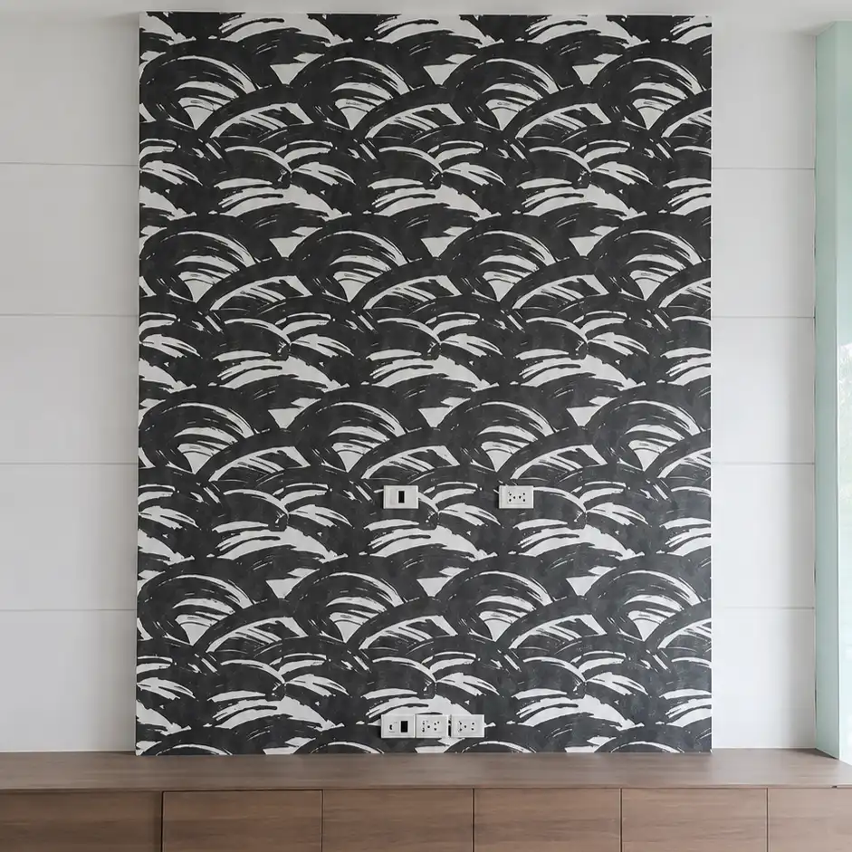 Black and white scalloped brushstroke pattern wallpaper above a wood cabinet, wrapped mattress in the foreground