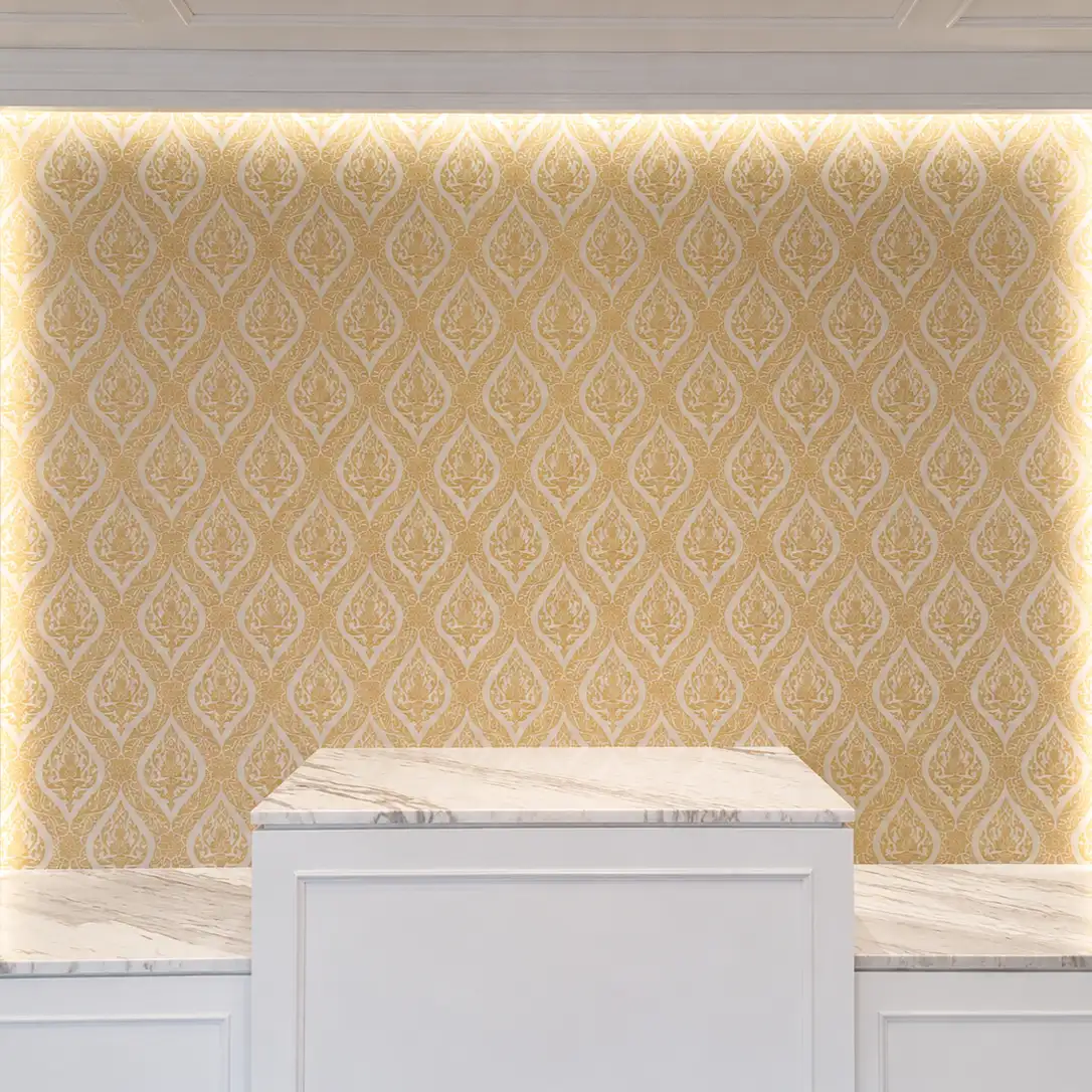 Gold Thai-motif damask wallpaper backlit behind a white marble reception counter
