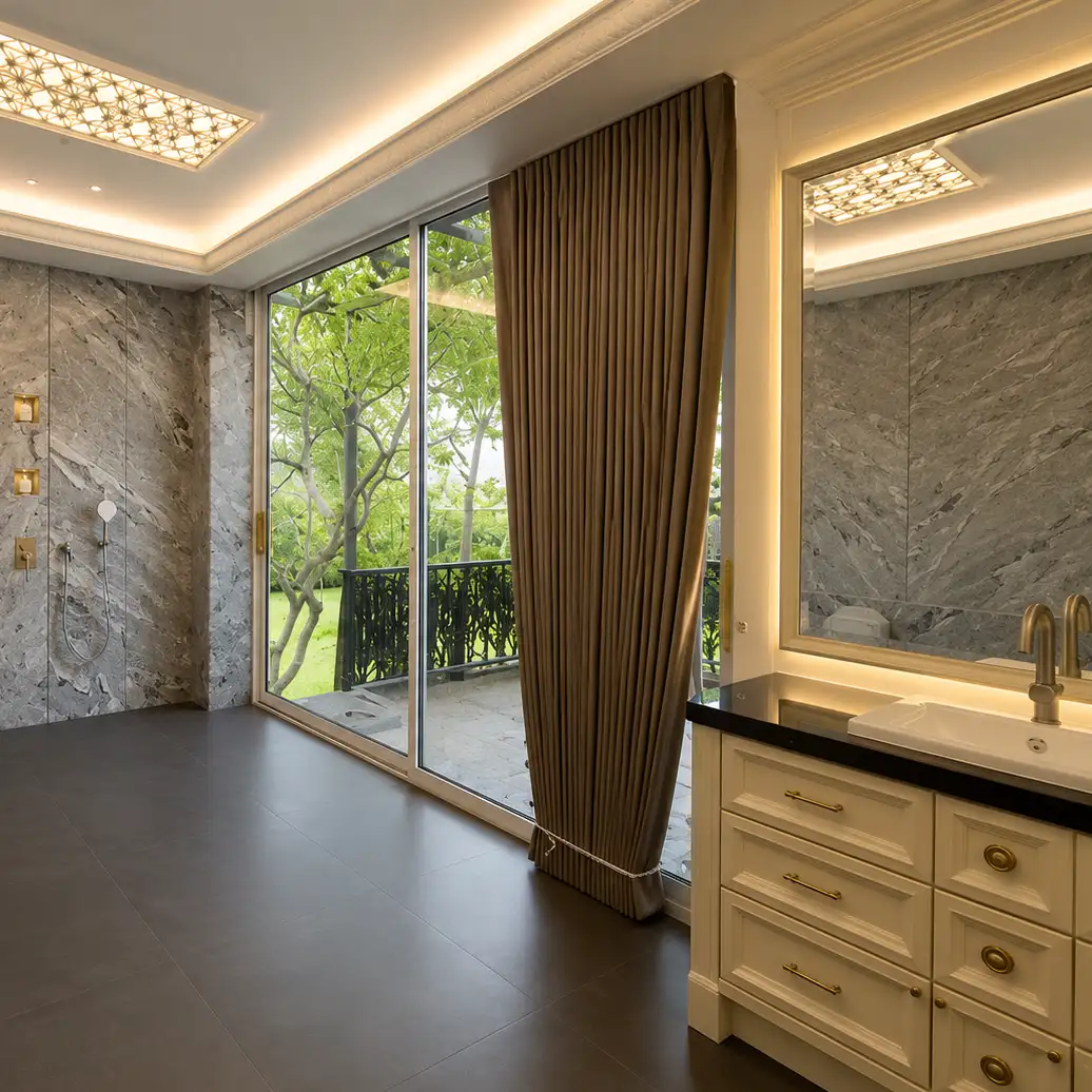 Marble bathroom with rainfall shower, accessible toilet and gold curtain by the garden-view sliding door