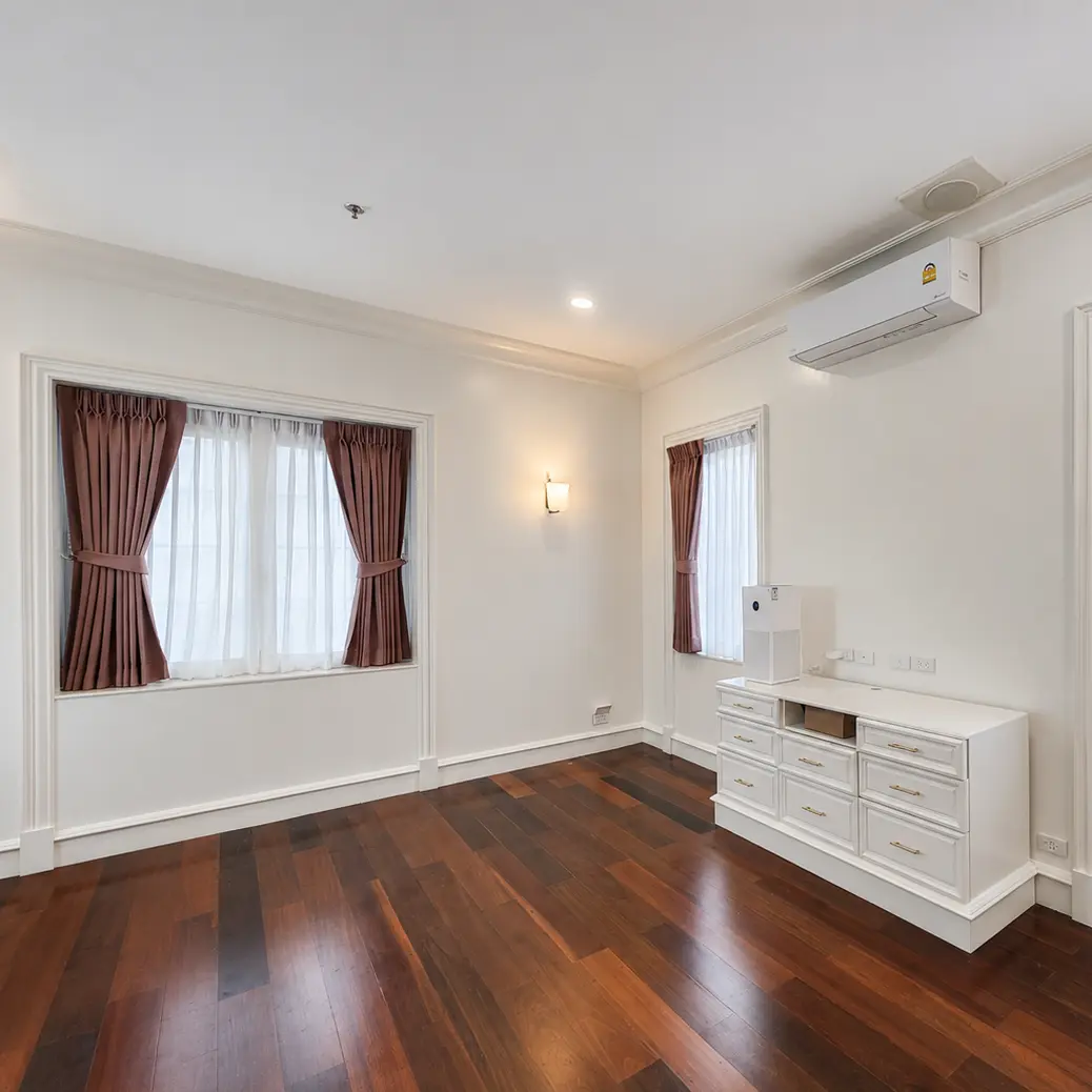 Bedroom with mauve pinch-pleat curtains on three windows