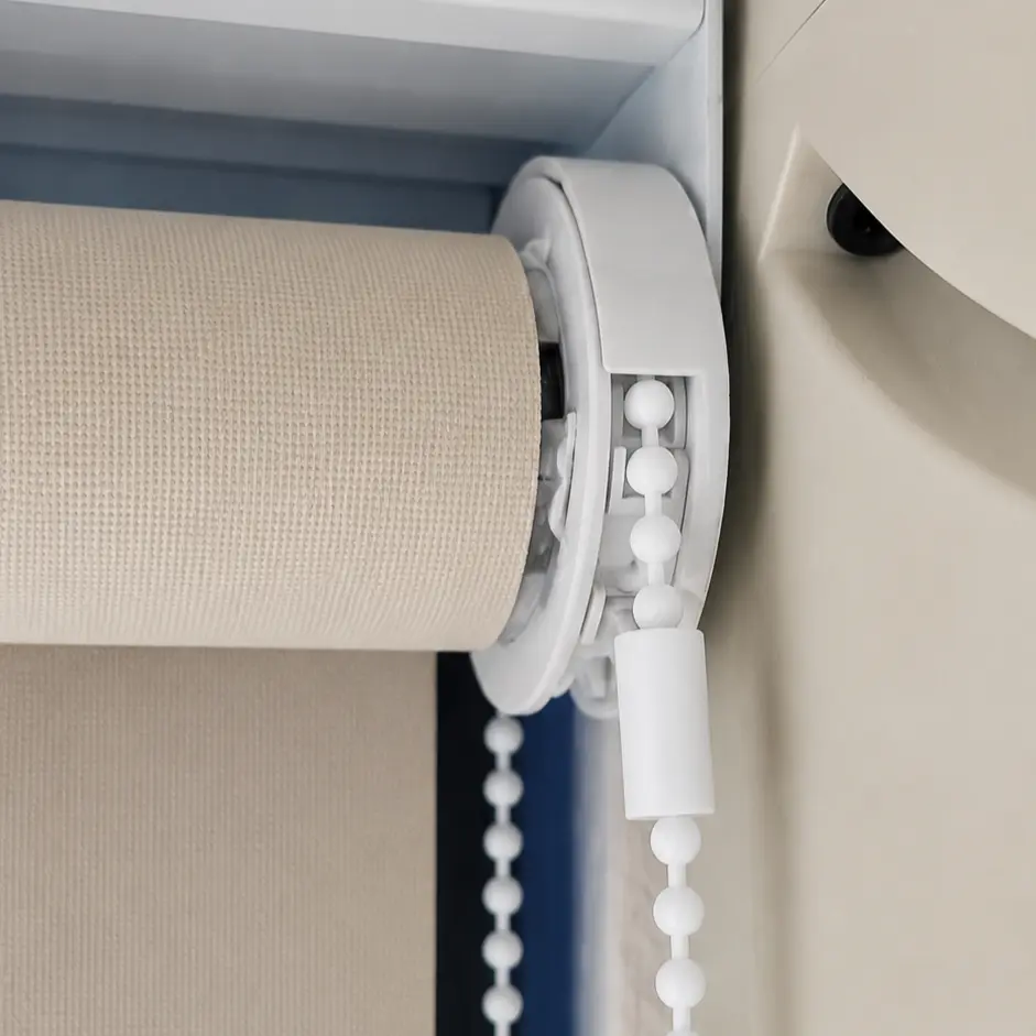 Close-up of a roller blind roller tube and bead chain mechanism mounted at the ceiling