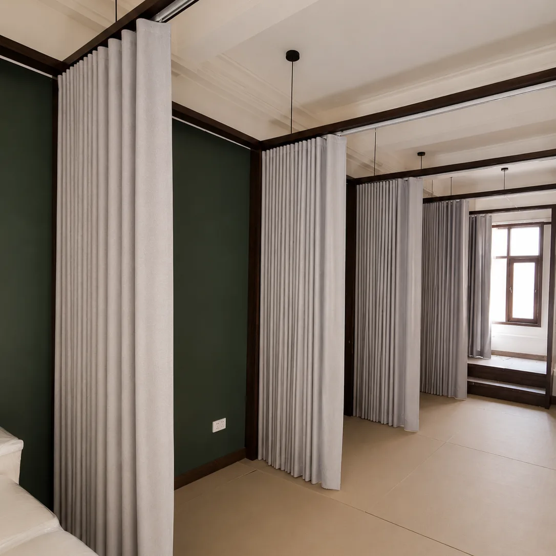 Corridor of private treatment rooms separated by pleated fabric curtain dividers