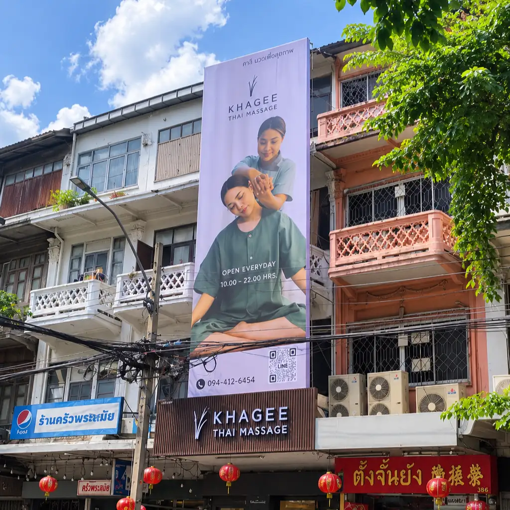 KHAGEE Thai Massage shopfront with a tall backlit signboard on a busy street
