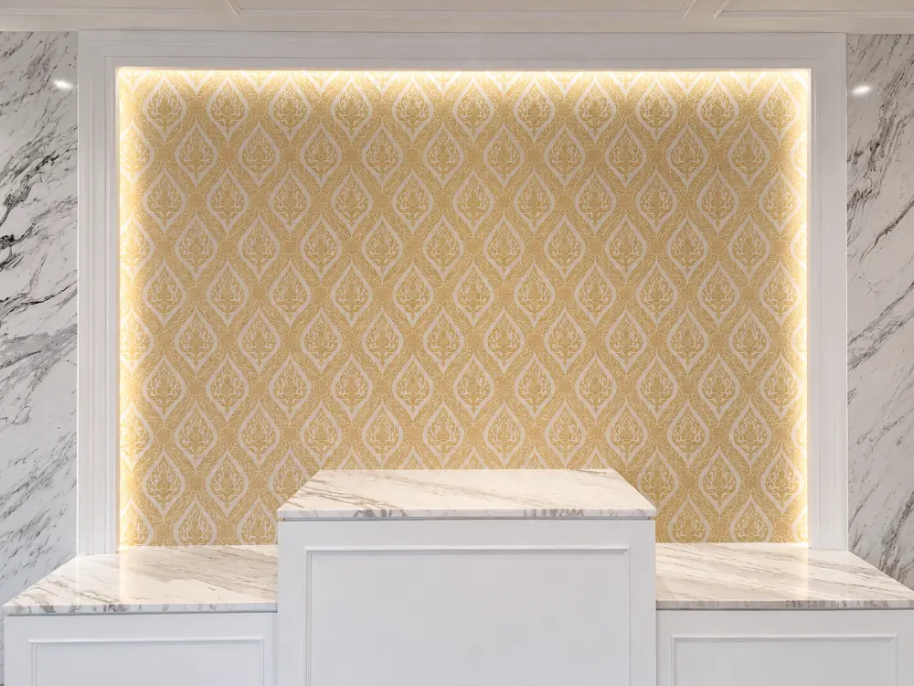 Gold Thai-motif damask wallpaper backlit behind a marble reception counter