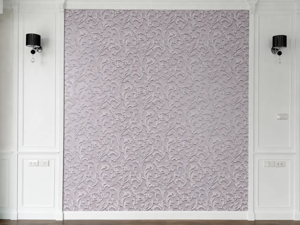 Textured pink damask wallpaper panel framed by white wall molding